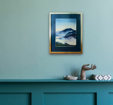 Erinevates sinistes toonides sume akvarellmaal mägedest udus. Maria Välja akvarellmaal raamis.